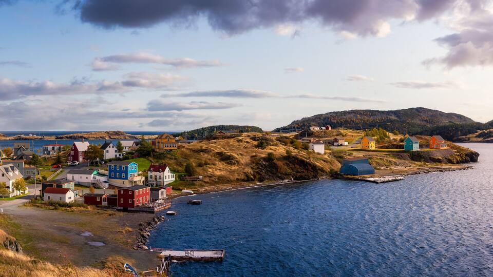 Panoramic view of a small town on the Atlantic Ocean Coast. Dramatic Colorful Sunrise Sky Art Render. Taken in Trinity, Newfoundland and Labrador, Canada.