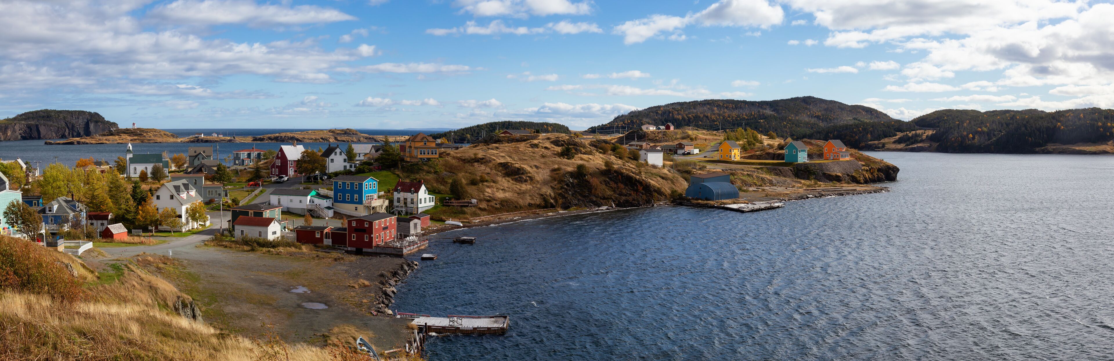 Aerial panoramic view of a small town on the Atlantic Ocean Coast during a sunny day. Taken in Trinity, Newfoundland and Labrador, Canada.