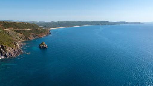 Aerial view of Plagemesu beach located in the municipality of Gonnesa, in southern Sardinia, Italy. The coast is characterized by steep mountains that descend to the sea.