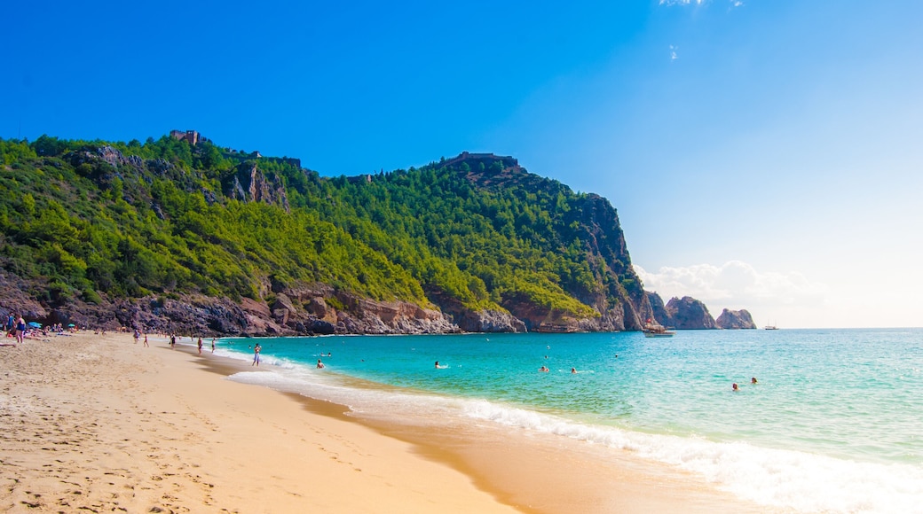 Beach of Cleopatra with sea and rocks of Alanya peninsula, Antalya, Turkey. Beautiful landscape of tourist destination with high green cliff and Castle of Alanya.