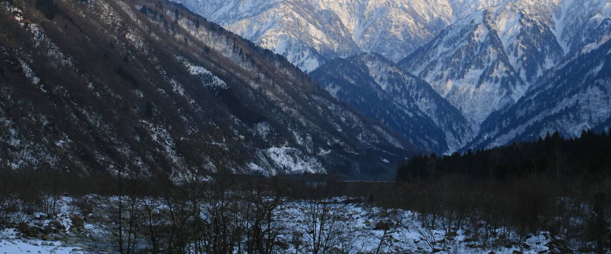 Snow-covered mountains, a valley, and a lake.