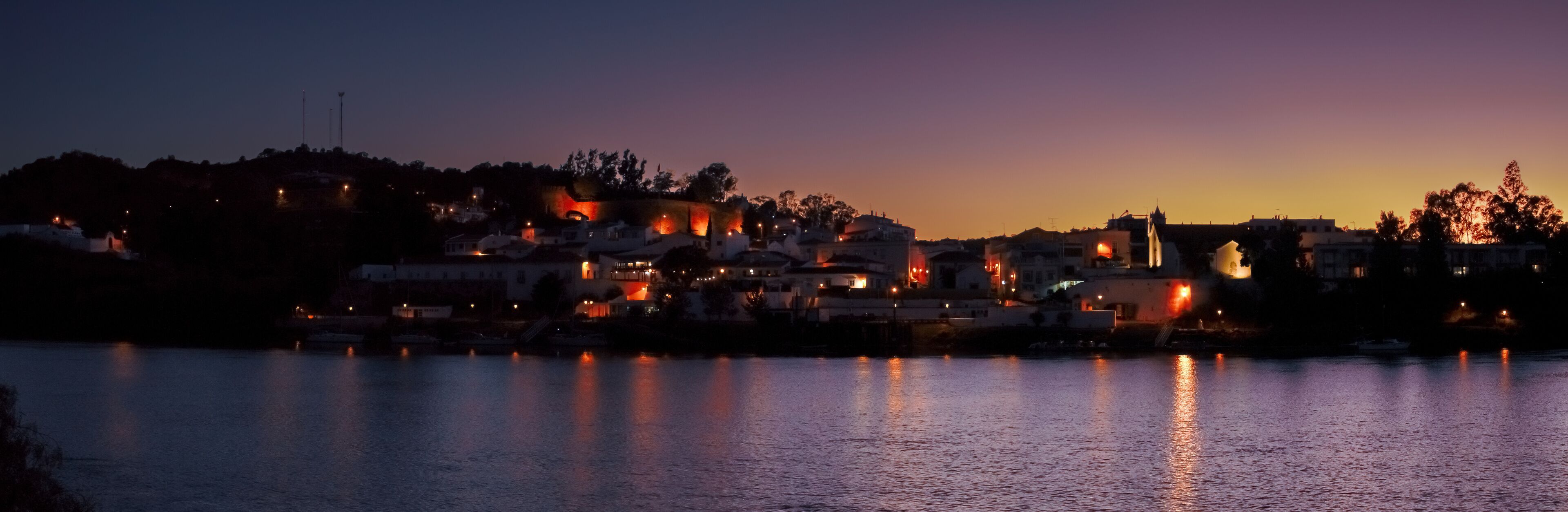 Alcoutim un pequeño pueblo del Algarve en Portugal. Alcoutim al anochecer a orillas del río Guadiana. Casas blancas con las últimas luces del día y las farolas encendidas.