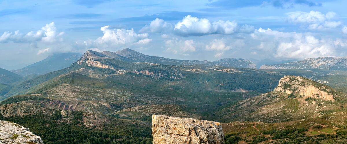 A mountainous landscape with rocky outcrops and dense forests.