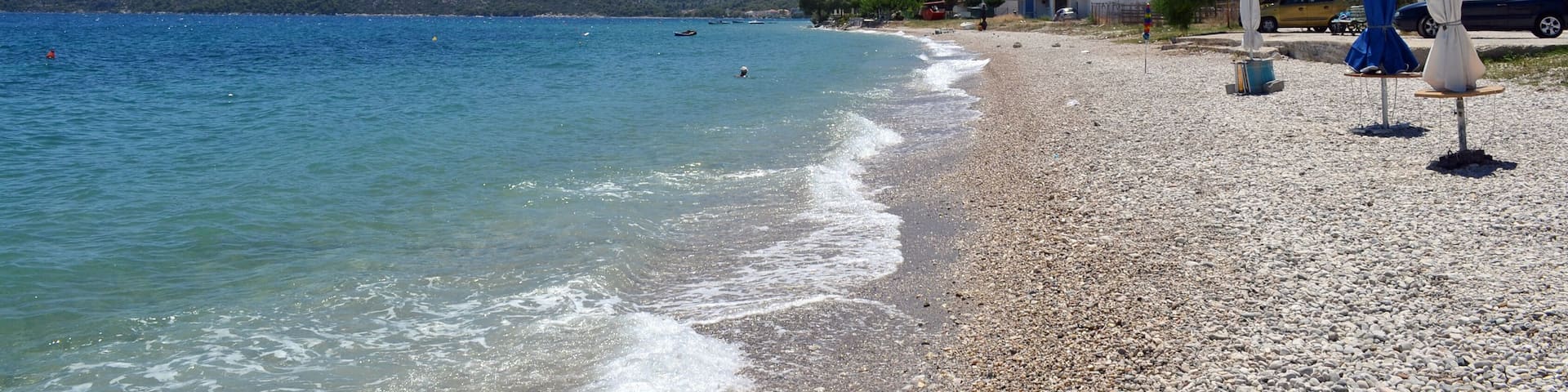 Beach in Loutra Oraias Elenis meaning Baths of beautiful Helen, a village in Corinthia, Greece, situated on the coast of the Saronic Gulf.