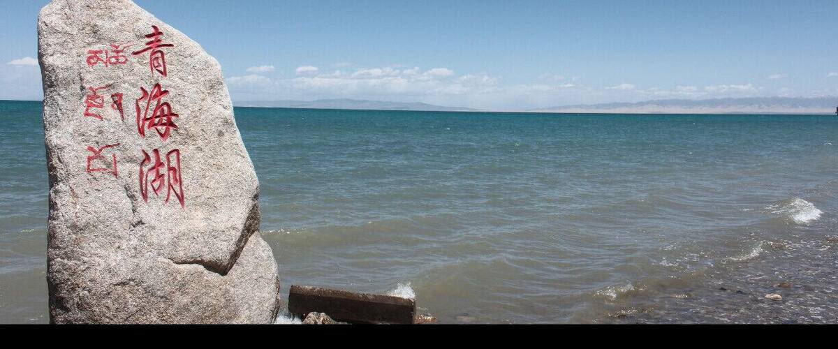 Double language milestone (Chinese and Tibetan). Qinghai Lake is easy to reach by bus from Xining