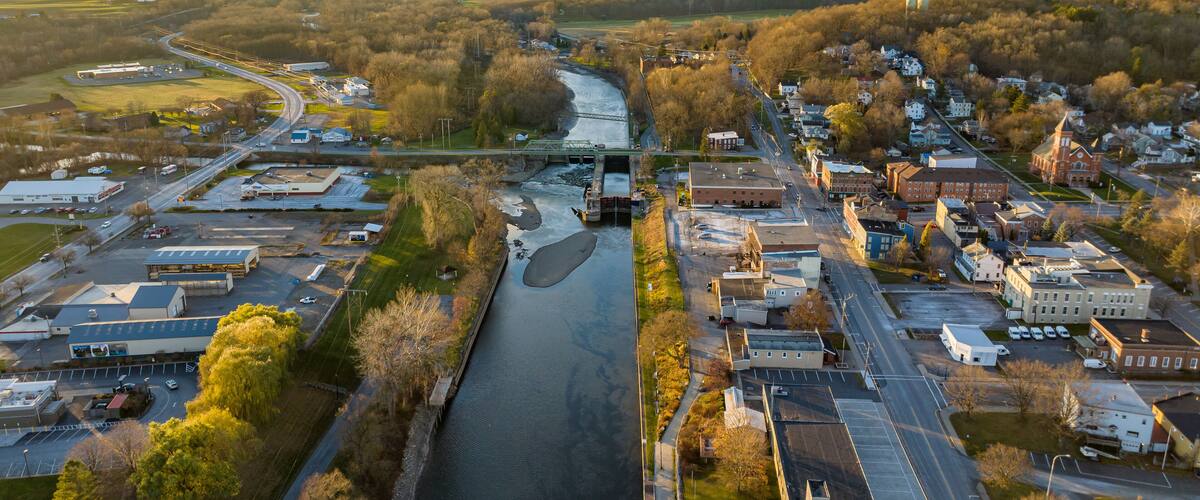 An aerial view of a town with a river, roads, and buildings.