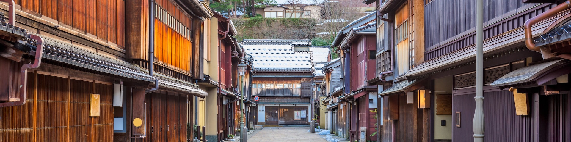 Eine traditionelle japanische Straße mit Holzbauten und blauem Himmel.