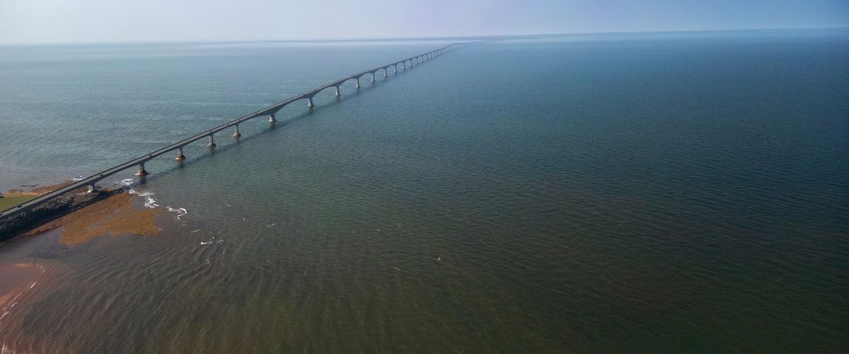 A long bridge over calm water.