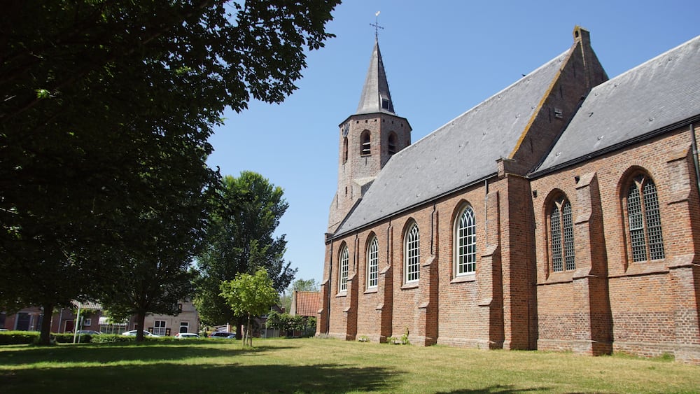 A church with a tall steeple and arched windows.