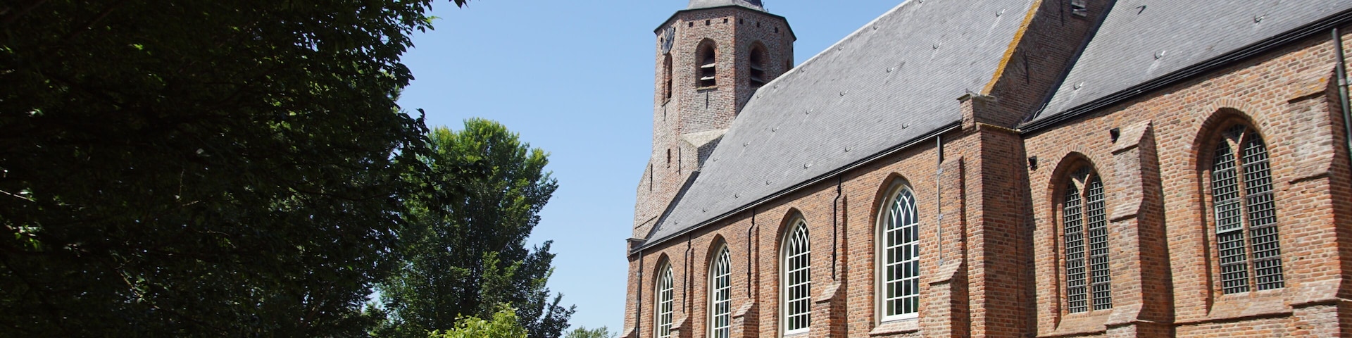 Eine Kirche mit einem hohen Turm und Rundbogenfenstern.