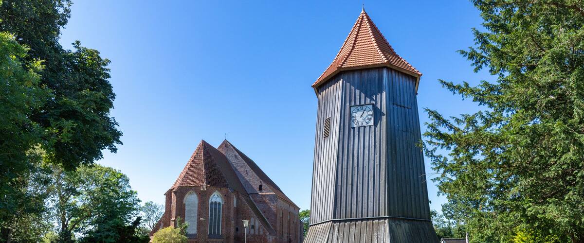 A church with a bell tower and a brick pathway leading to it.