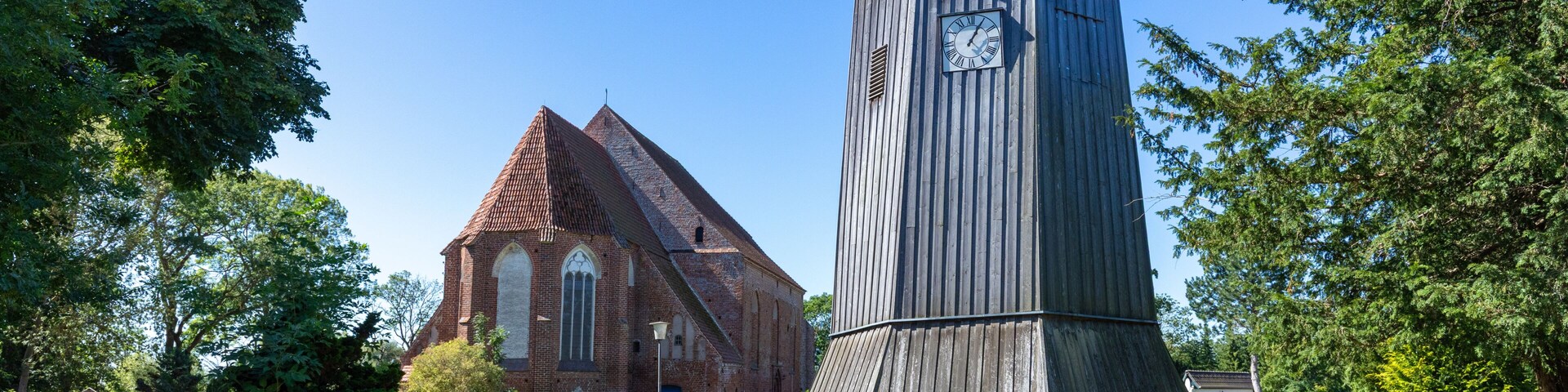 A church with a bell tower and a brick pathway leading to it.
