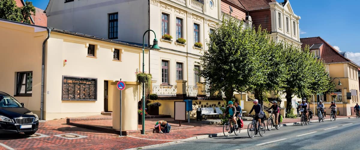 A street with cyclists, a café, and traditional architecture.