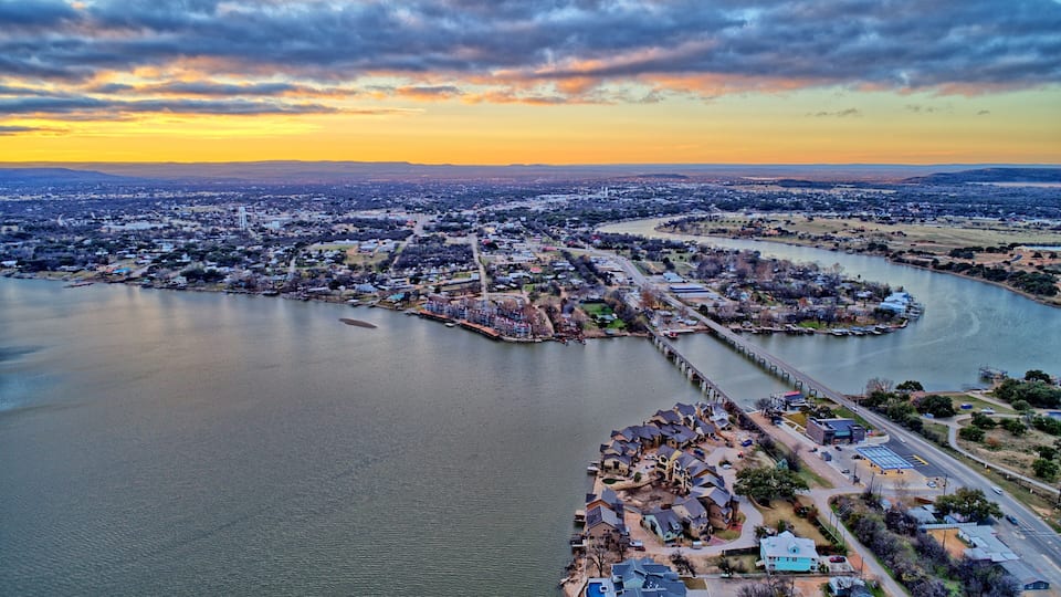 A river flowing through a city with a bridge and residential areas.