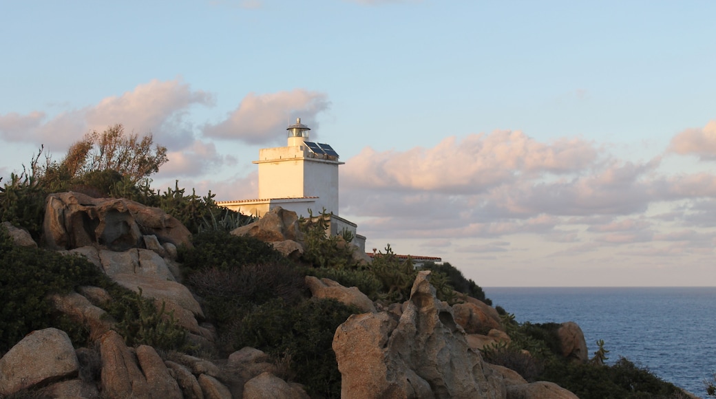Um farol numa costa rochosa, com o mar ao fundo.