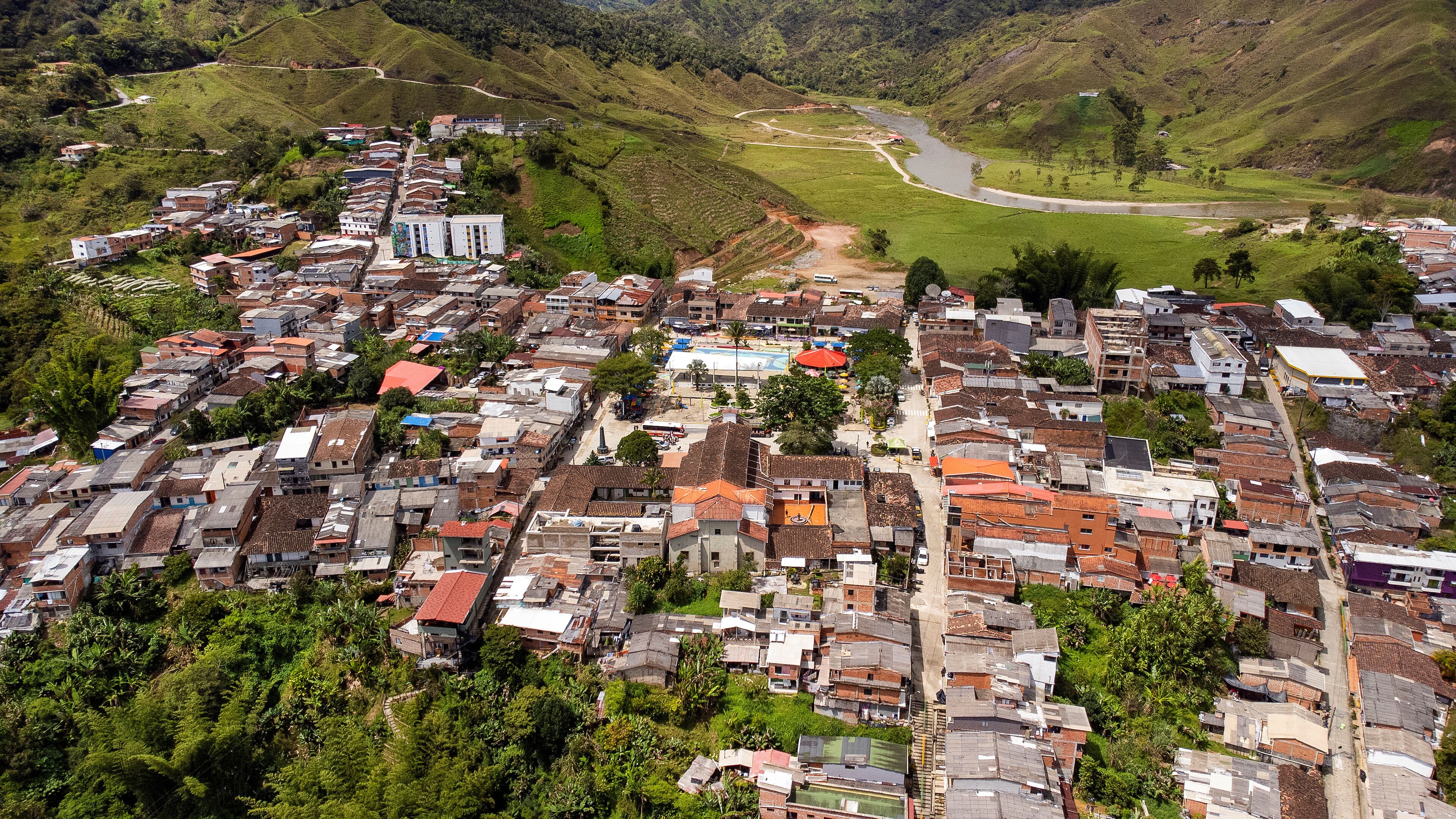 A densely packed hillside town with a river running through the valley.
