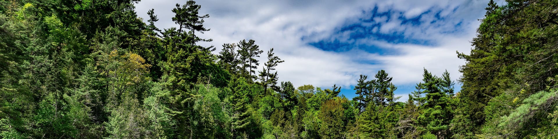 Chippewa Falls in Algoma, Ontario, Canada. Wide and cascading Chippewa Falls are located at halfway point of Trans-Canada Highway. Highway 17 at Chippewa River, Batchawana Bay. Fly fishing in waders.