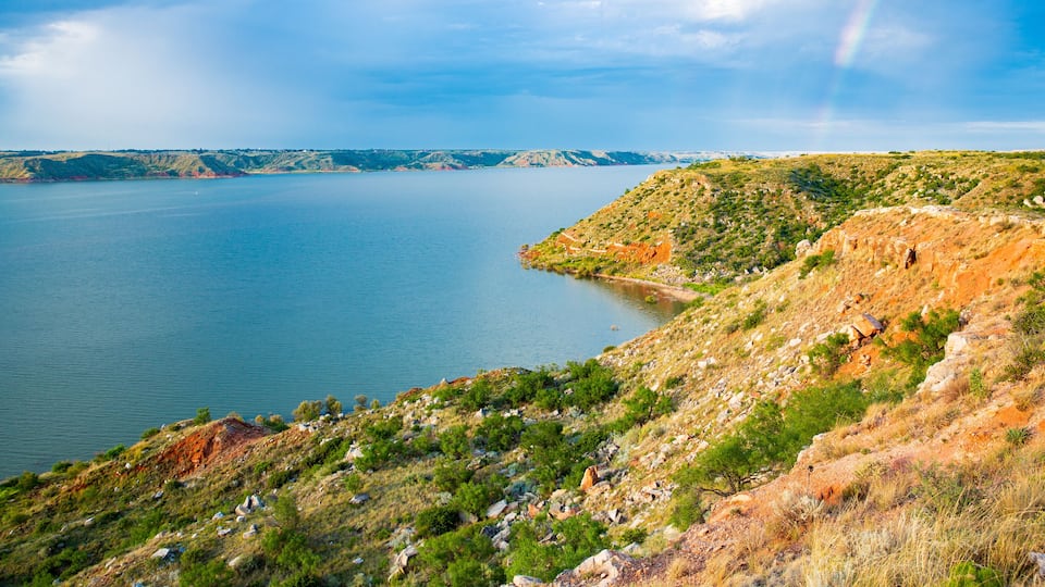 A large body of water surrounded by hills with sparse vegetation.