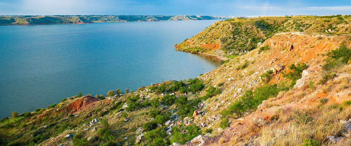 A large body of water surrounded by hills with sparse vegetation.