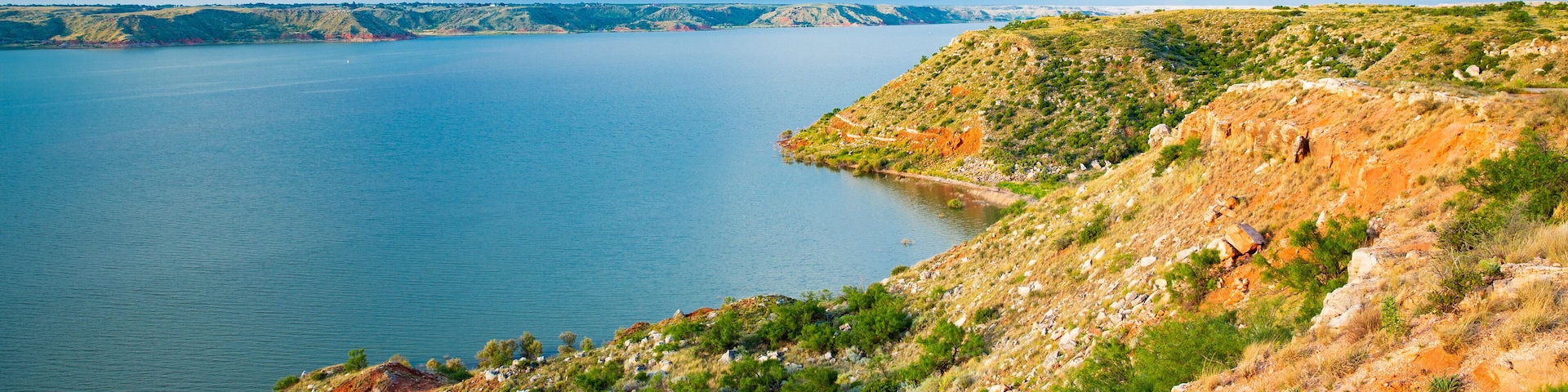 A large body of water surrounded by hills with sparse vegetation.