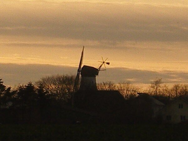 A windmill silhouetted against a sunset sky.