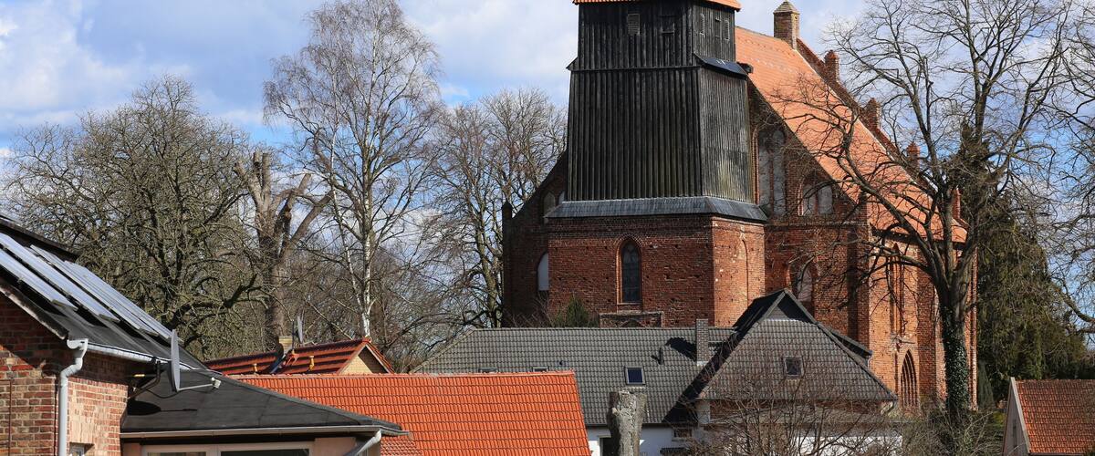 A church with a red-tiled roof and a tall, pointed steeple.