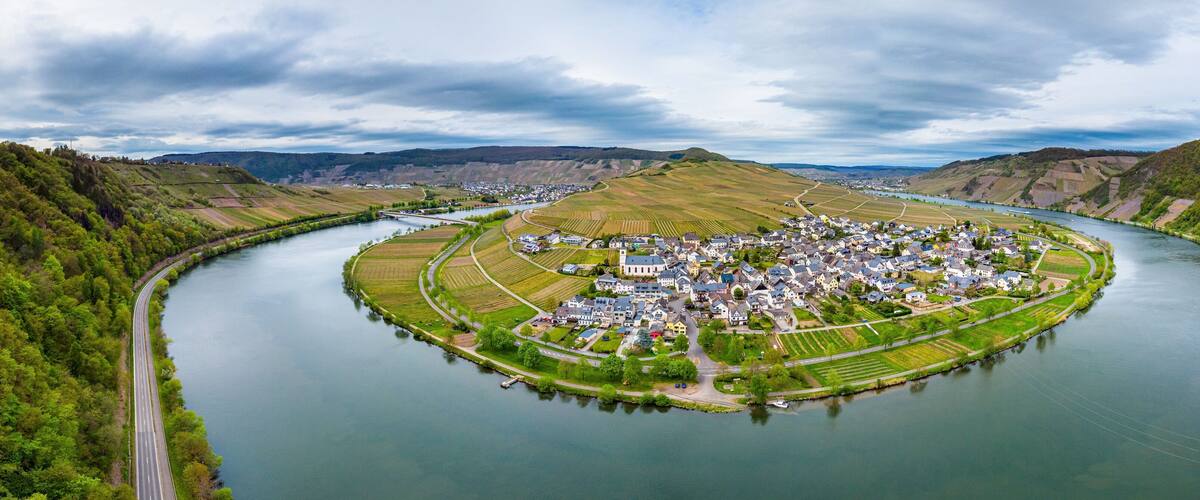 A river town surrounded by hills and fields.