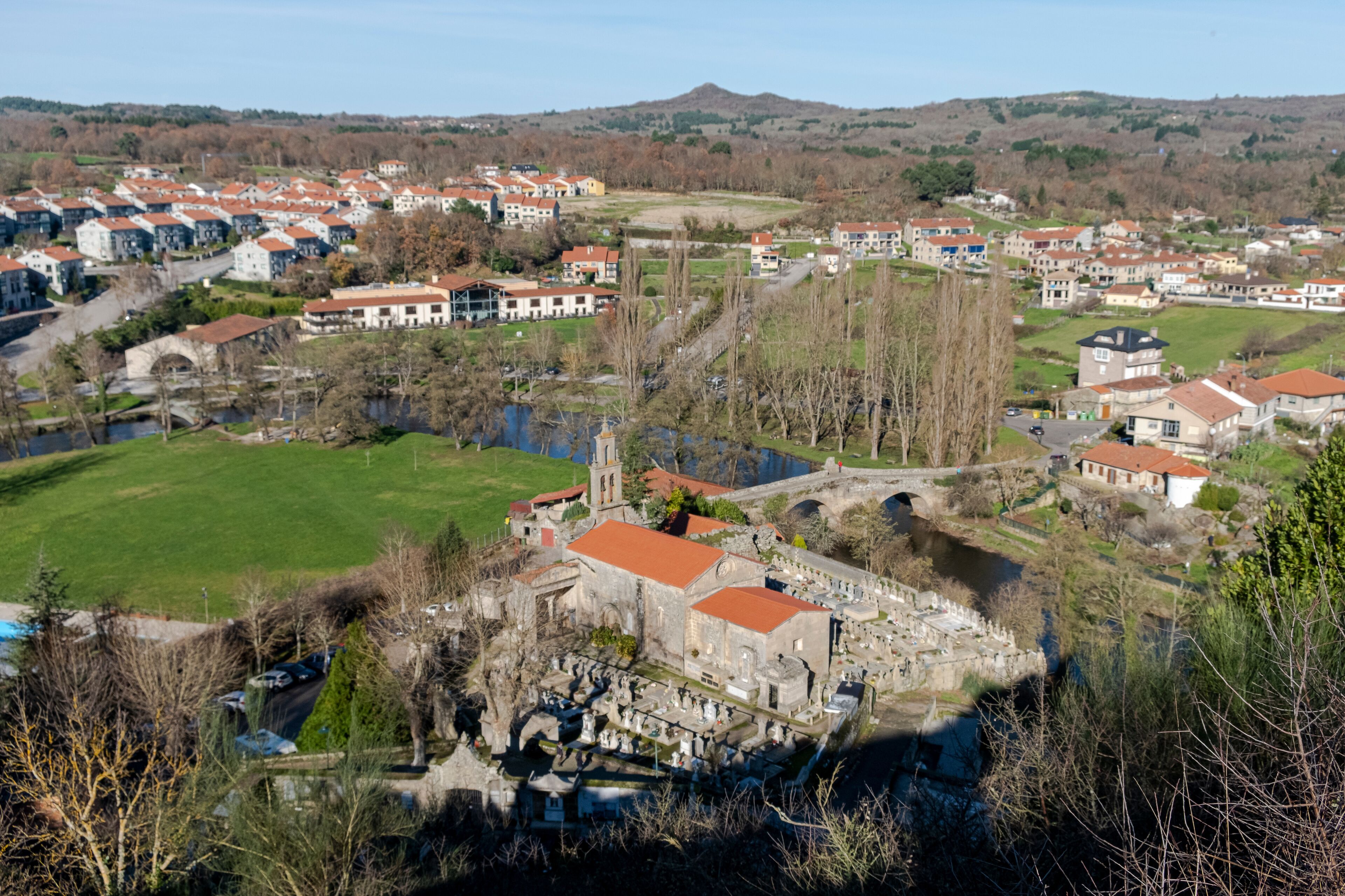 A historic town with a river, a bridge, and a prominent church.