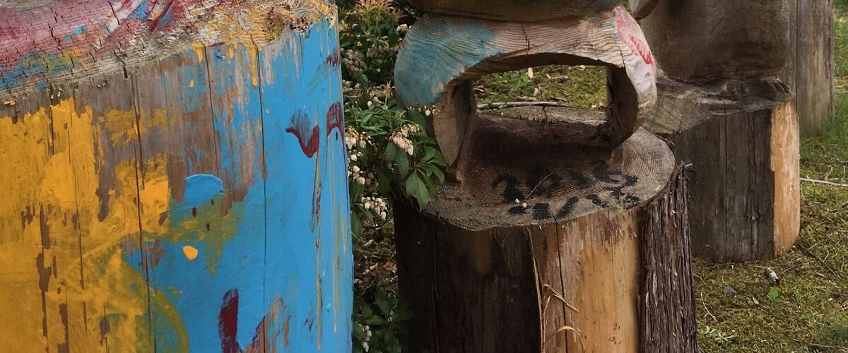 Colorful wooden sculptures in a garden.