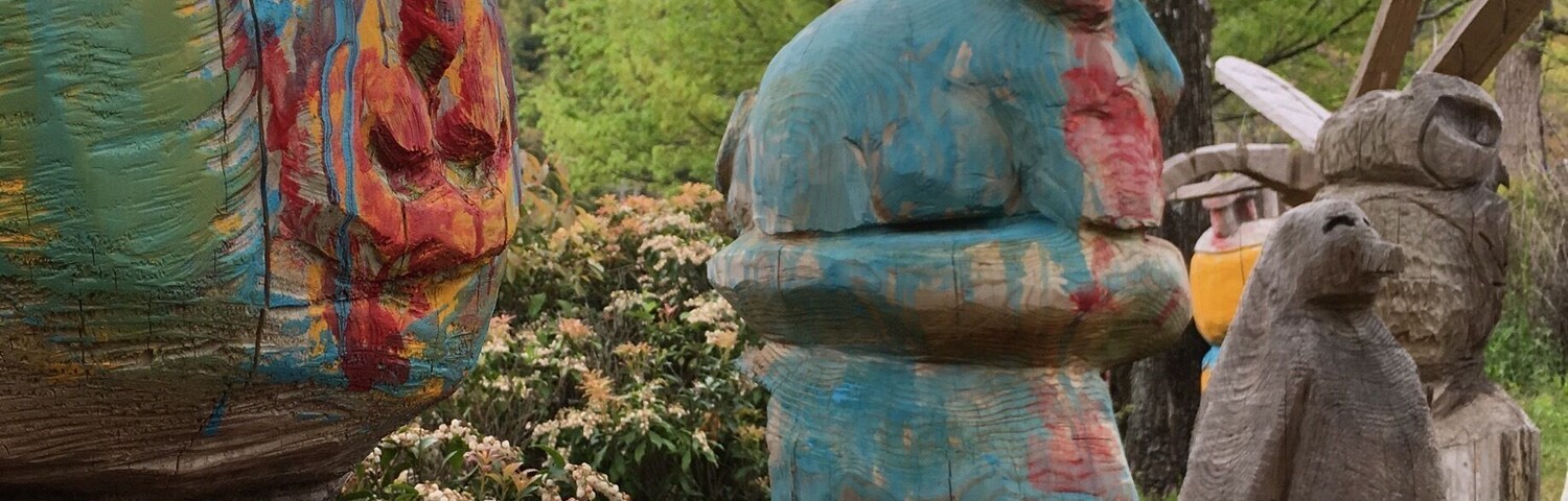 Colorful wooden sculptures in a garden.