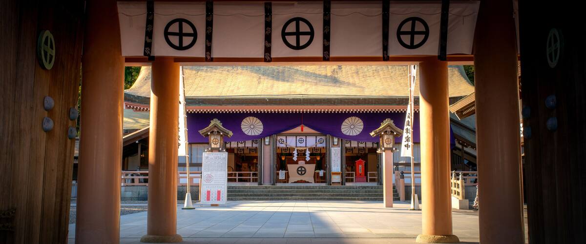 A traditional Japanese gate with wooden pillars and a purple roof.