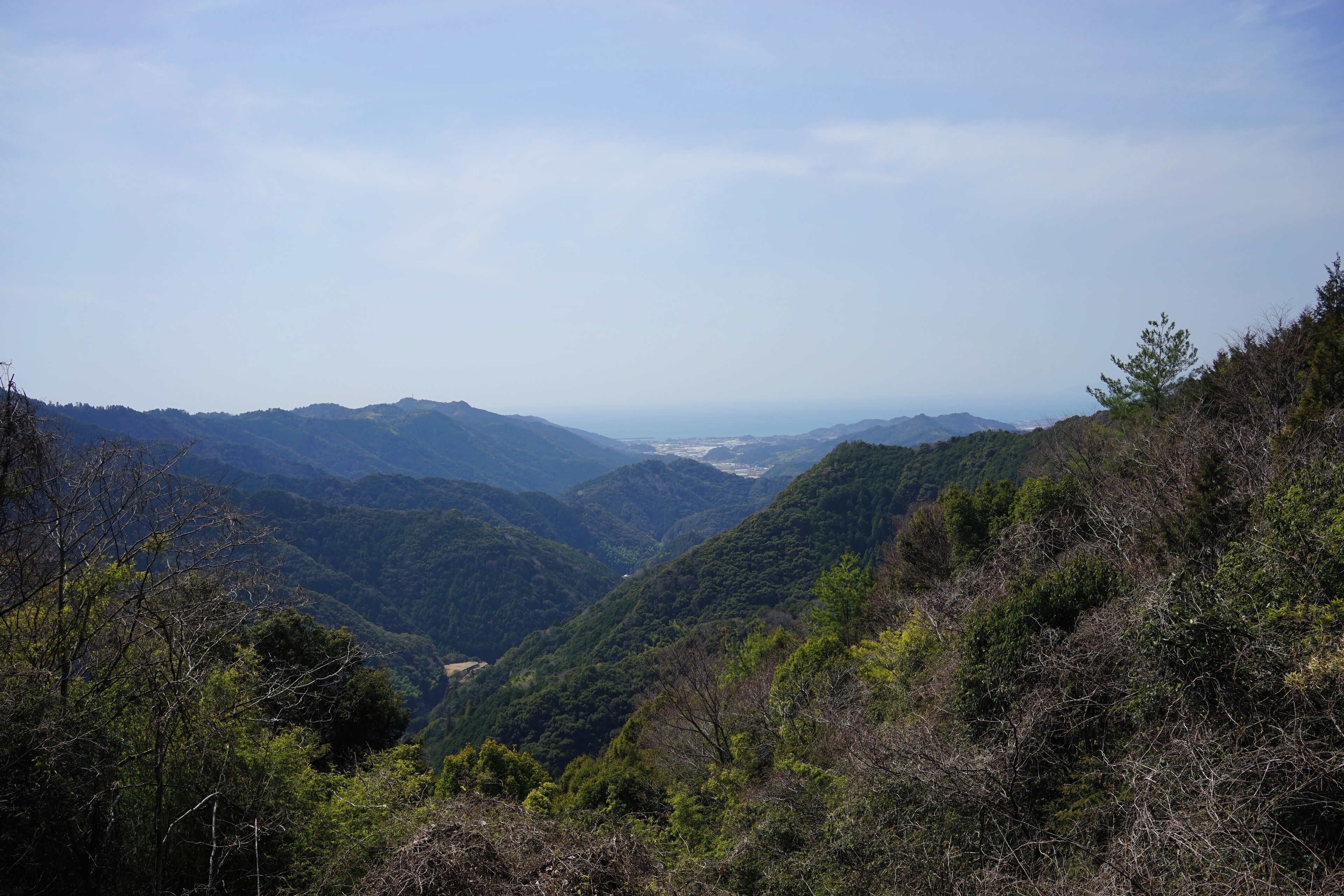A mountainous landscape with dense forests and a valley.