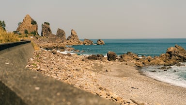 A rocky coastline with prominent rock formations and a calm sea.