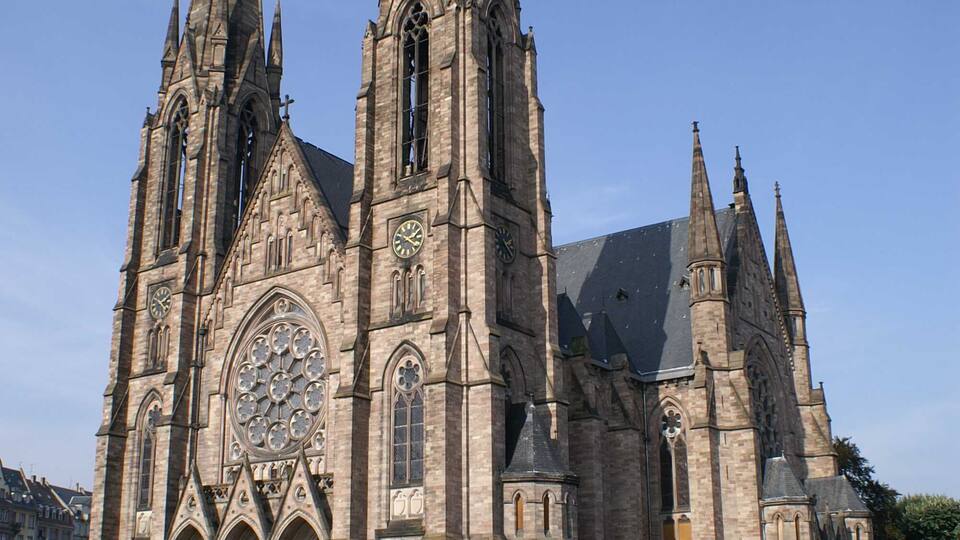 A large Gothic-style cathedral with multiple spires and a large central rose window.