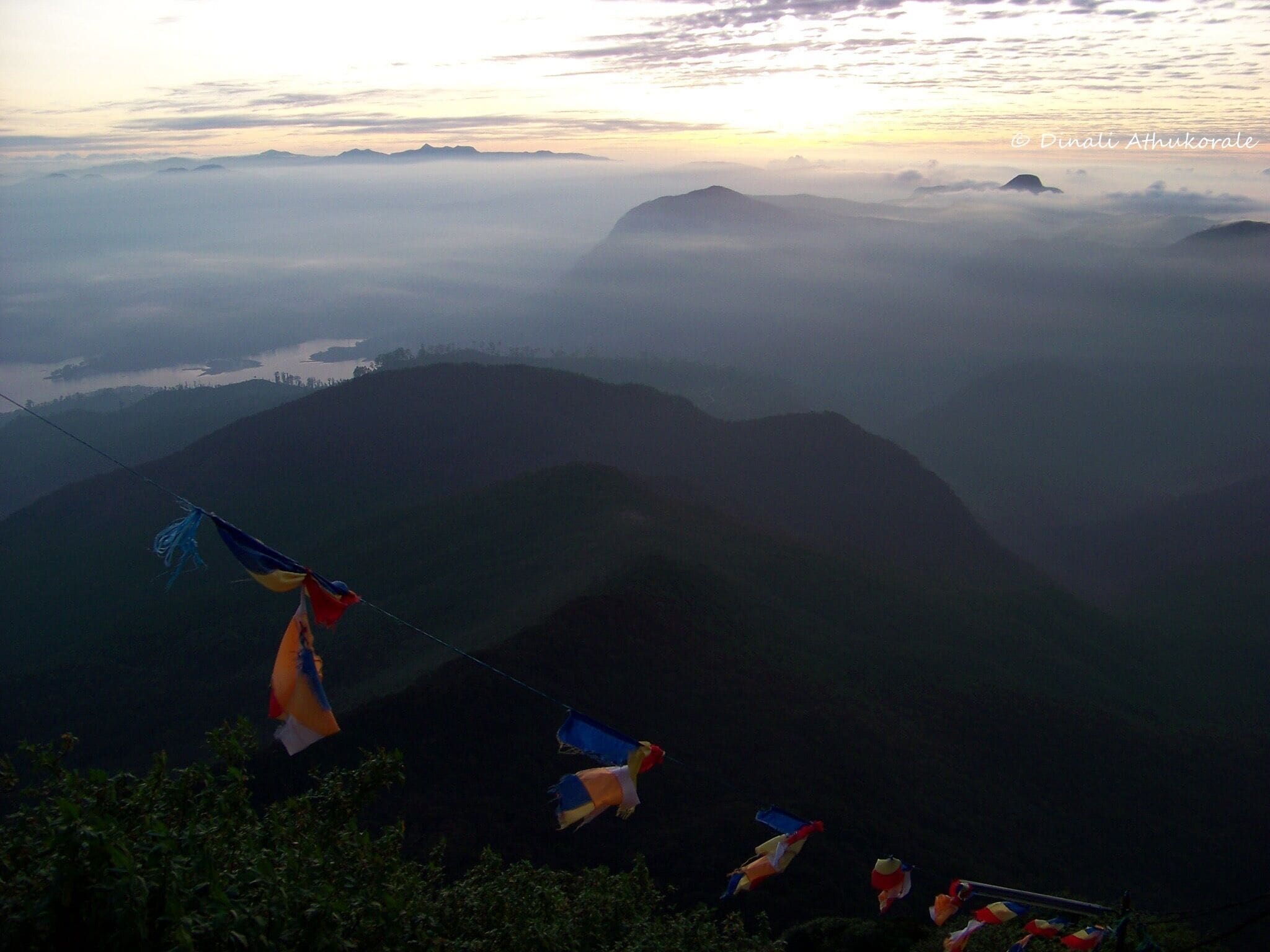 A mountainous landscape with prayer flags strung across the valley.