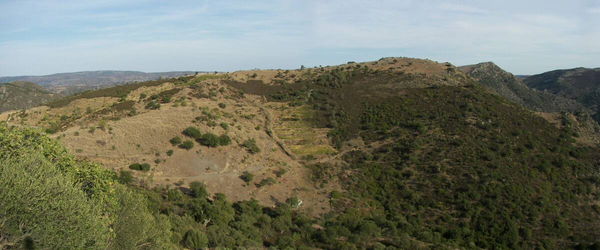 A mountainous landscape with rugged terrain and sparse vegetation.