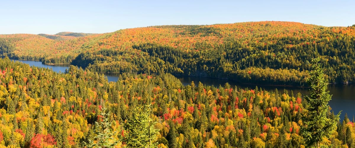 A lake surrounded by forested hills with autumn foliage.