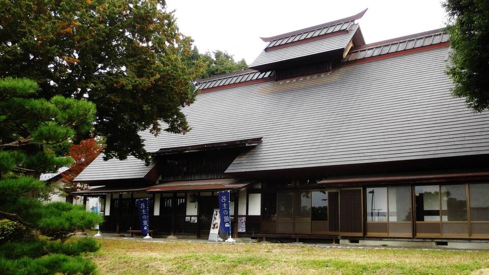A traditional Japanese building with a tiled roof and wooden structures.