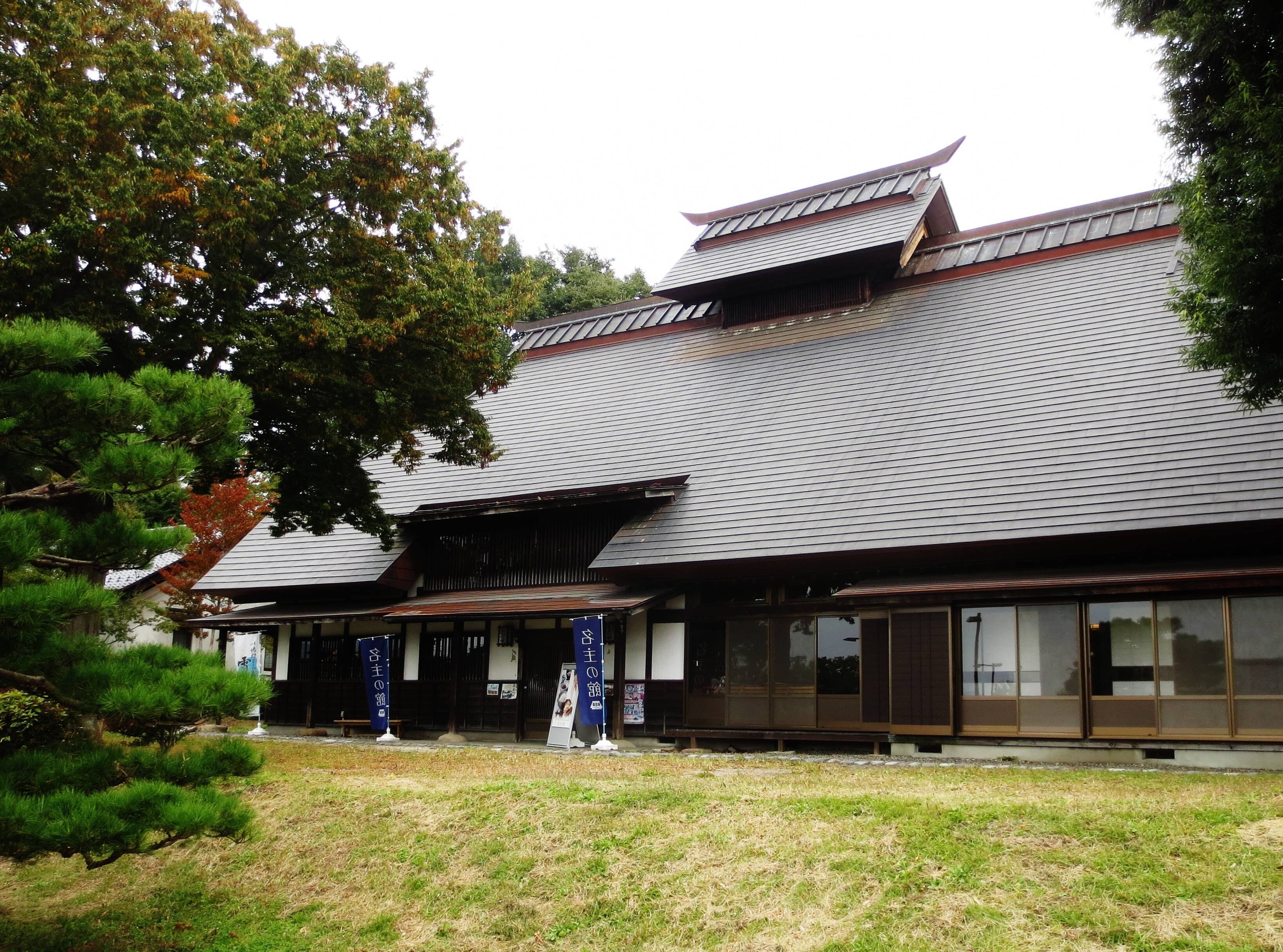 A traditional Japanese building with a tiled roof and wooden structures.