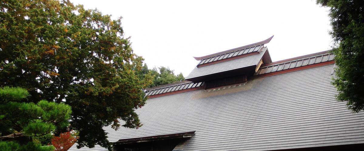 A traditional Japanese building with a tiled roof and wooden structures.