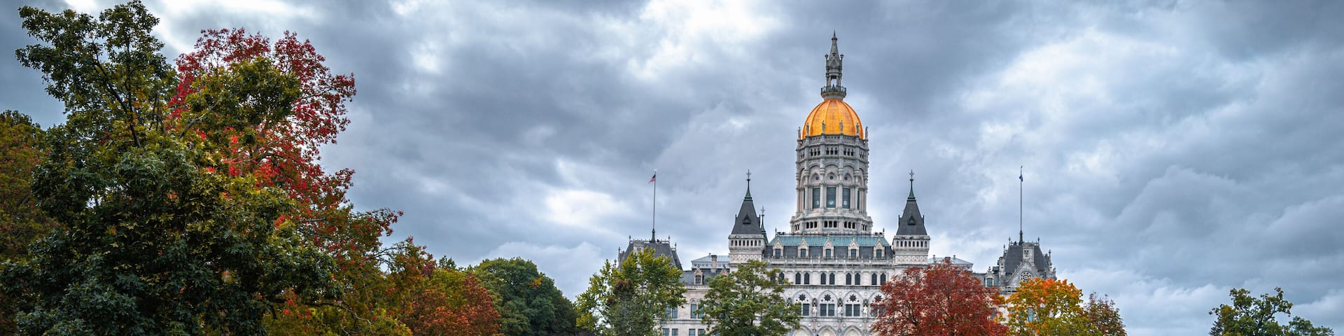 Dramatic cloudscape and autumn landscape over Connecticut State Capital building in Bushnell Park in Hartford, Connecticut