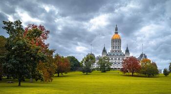 Dramatic cloudscape and autumn landscape over Connecticut State Capital building in Bushnell Park in Hartford, Connecticut