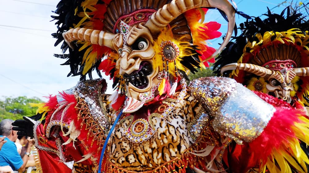 A colorful, ornate mask with intricate patterns and vibrant feathers.