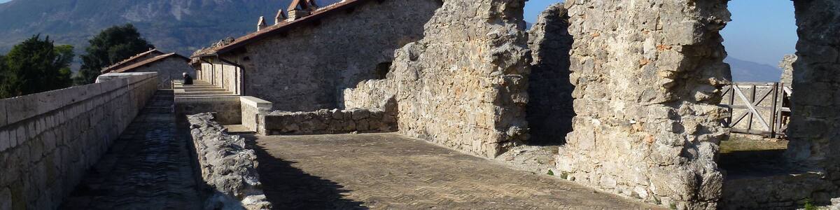 Ancient stone ruins with a mountain in the background.