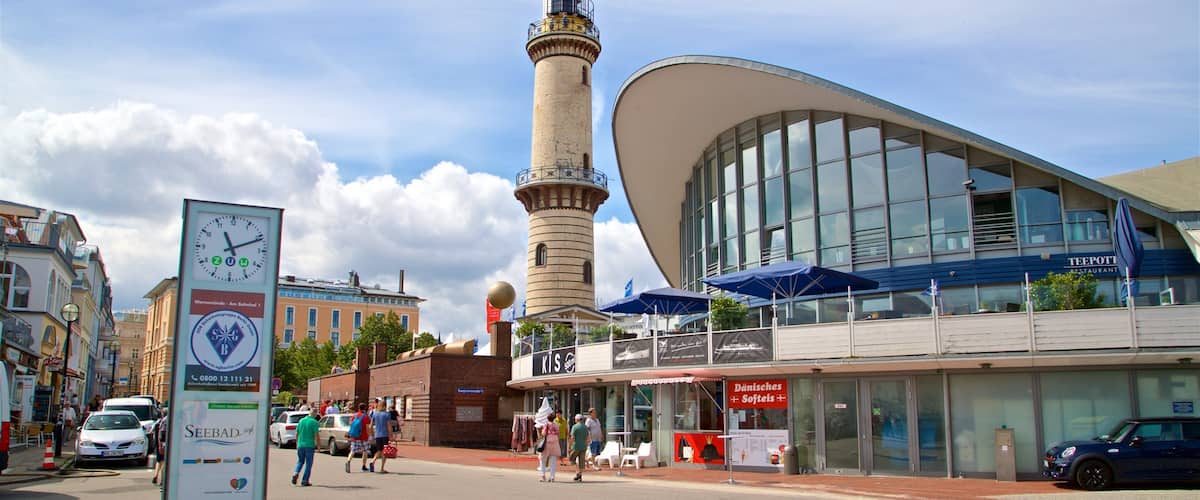 A modern building with a curved facade, a tall tower, and a signboard with a clock.