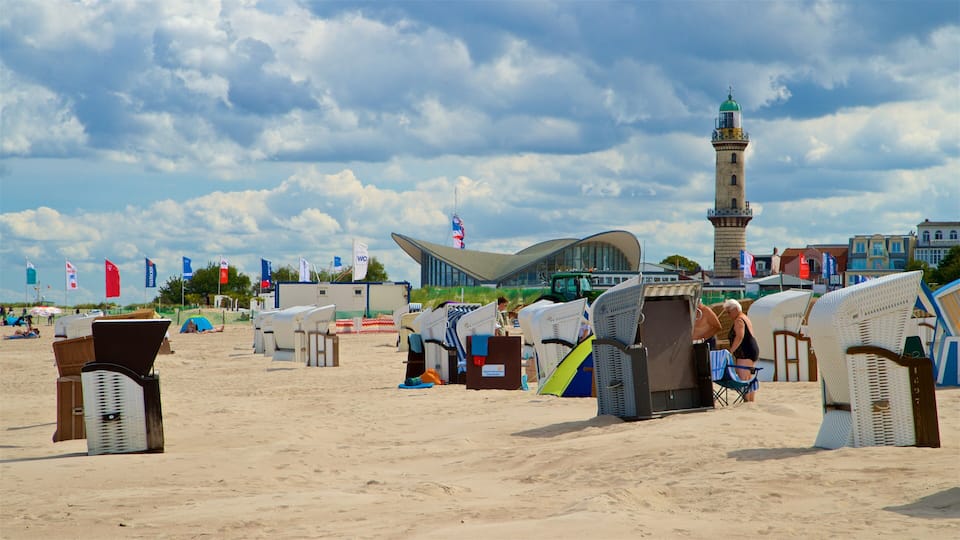 A beach with beach chairs and a modern building in the background.