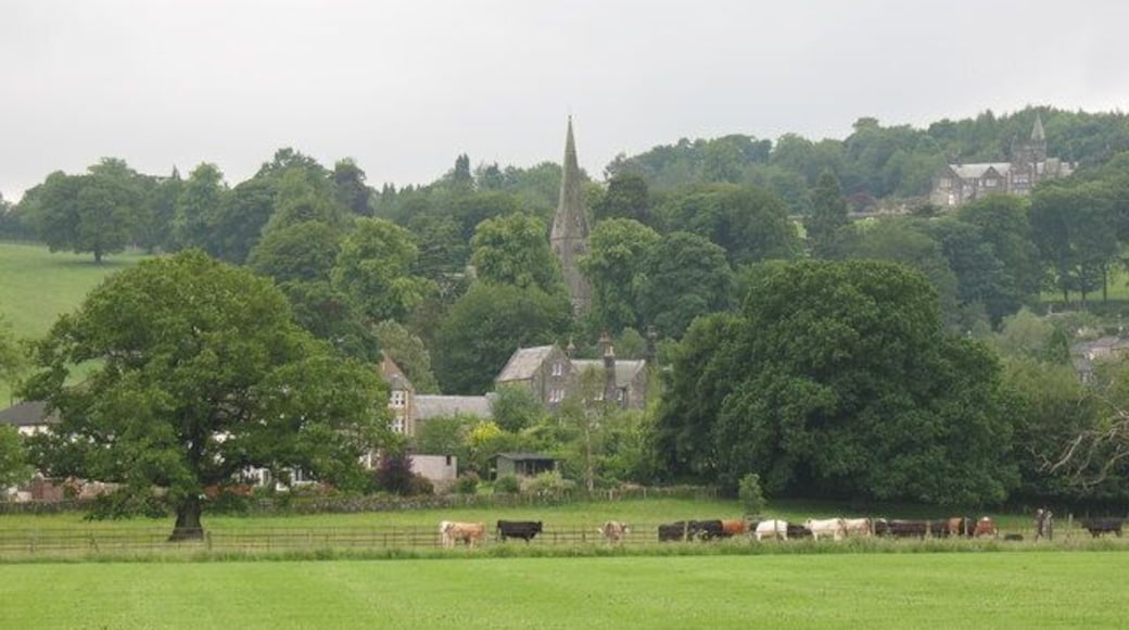View across playing fields at Birstwith The goalposts have been taken down for the summer, so there is a clear view of grazing cattle and the village church on the hill.