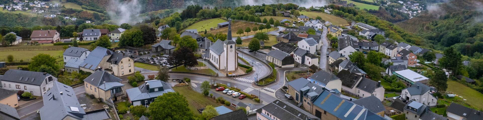Aerial drone view of Bourscheid village in countryside of Luxembourg on cloudy day.