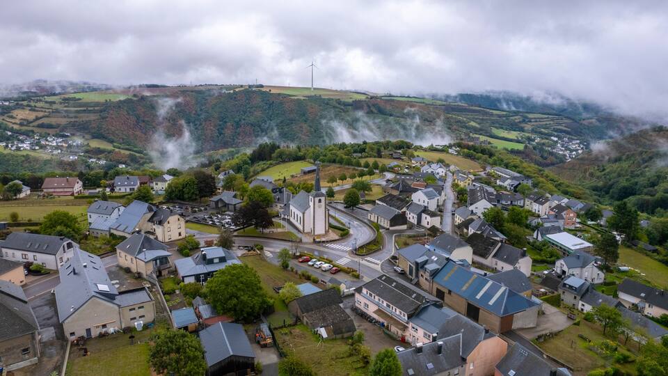 Aerial drone view of Bourscheid village in countryside of Luxembourg on cloudy day.