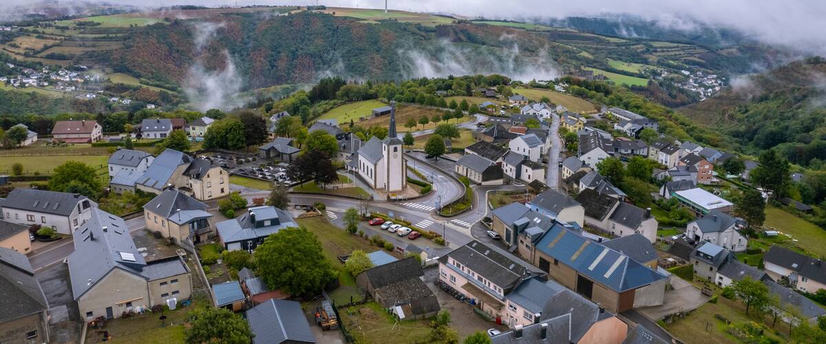 A village with houses, a church, and a wind turbine.